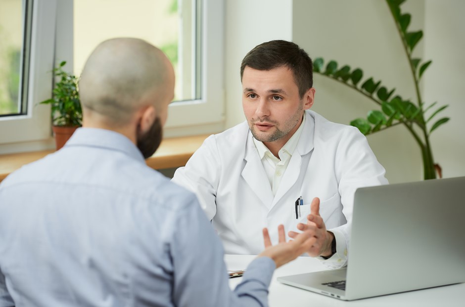 Médico urologista explicando para seu paciente, homem por volta dos 45 anos, sobre algumas maneiras de como aumentar o pênis.